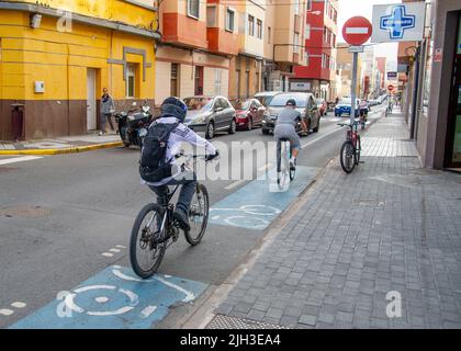 Februar 20 2022 - Radfahrer fahren in Las Palmas de Gran Canaria auf den Straßen des alten Zentrums vorbei an bunten Häusern Stockfoto