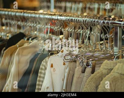 Modische Kleidung in einem Boutique-Geschäft. Einkaufen. Modische Freizeitkleidung für Damen im Geschäft am Schaufenster. Niemand, Straßenfoto Stockfoto