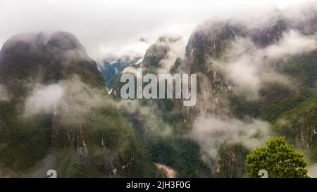 Wunderschöne Aussicht auf die hohen Anden von Machu Piccu in Peru, an nebligen Tagen am frühen Morgen. High-Angle-Ansicht. Natürlicher und historischer Hintergrund Stockfoto