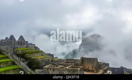 Stone Temple in Machu Piccu am nebligen Tag am frühen Morgen. High-Angle-Ansicht. Natürlicher und historischer Hintergrund mit Kopierbereich. Blick auf Machu Picchu Stockfoto