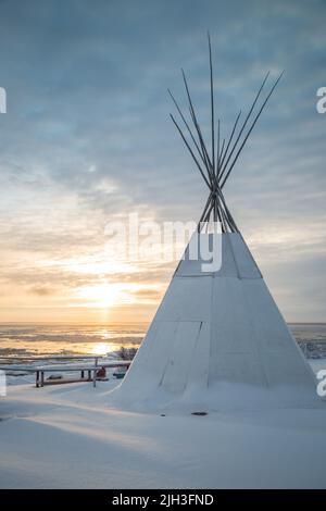 Traditionelles Tipi an der Küste des Great Bear Lake mit frühem Winteruntergang in der nördlichen indigenen Gemeinde Deline, Northwest Ter Stockfoto