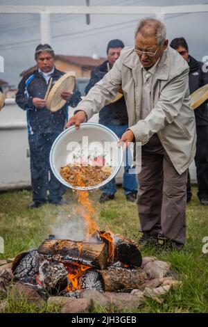 Älterer Dene-Mann, der das Feuer bei der traditionellen indigenen Feuerfütterungszeremonie in der nördlichen Gemeinschaft von Deline, Northwest Territories, Kanada, füttert Stockfoto