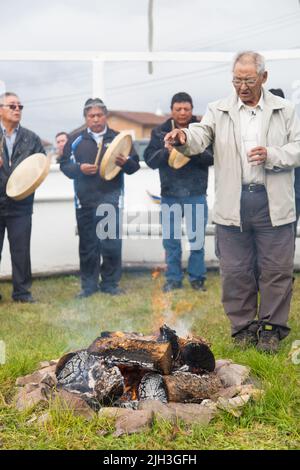 Dene älterer Mann, der die Feuerfütterung in der nördlichen Gemeinde Deline, Northwest Territories, Kanada, durchführt Stockfoto