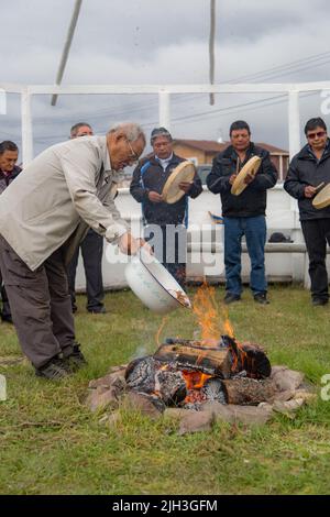 Älterer Dene-Mann, der das Feuer bei der traditionellen indigenen Feuerfütterungszeremonie in der nördlichen Gemeinschaft von Deline, Northwest Territories, Kanada, füttert Stockfoto