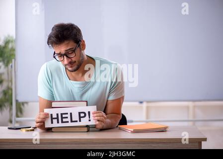 Junge Schüler, die sich auf Prüfungen im Klassenzimmer vorbereiten Stockfoto