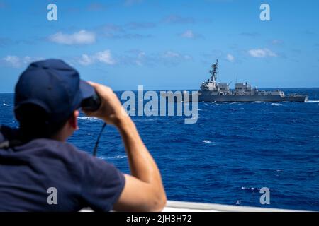 PAZIFISCHER OZEAN (13. Juli 2022) ein Besatzungsmitglied der US-Küstenwache an Bord des Cutter USCGC Midgett (WMSL 757) schaut während einer Manövrierübung im Rahmen von Rim of the Pacific (RIMPAC) 2022 auf den Arleigh Burke-Klasse-Lenkraketen-Zerstörer USS Gridley (DDG 101). 26 Nationen, 38 Schiffe, vier U-Boote, mehr als 170 Flugzeuge und 25.000 Mitarbeiter nehmen vom 29. Juni bis zum 4. August an RIMPAC in und um die Hawaii-Inseln und Südkalifornien Teil. RIMPAC, die weltweit größte internationale maritime Übung, bietet eine einzigartige Ausbildungsmöglichkeit und fördert und unterstützt kooperative Aktivitäten Stockfoto