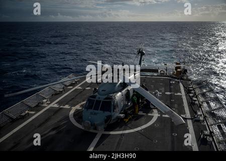 220713-G-LB555-1199 PAZIFISCHER OZEAN (13. Juli 2022) Crew-Mitglieder des US Coast Guard Cutter (USCGC) Midgett und US Navy Matrosen sichern sich einen Marine MH-60R Seahawk Hubschrauber auf dem Flugdeck des USCGC Midgett im Pazifischen Ozean, 12. Juli. 26 Nationen, 38 Schiffe, vier U-Boote, mehr als 170 Flugzeuge und 25.000 Mitarbeiter nehmen vom 29. Juni bis zum 4. August an RIMPAC in und um die Hawaii-Inseln und Südkalifornien Teil. RIMPAC, die weltweit größte internationale maritime Übung, bietet eine einzigartige Ausbildungsmöglichkeit und fördert und pflegt kooperative Beziehungen am Stockfoto