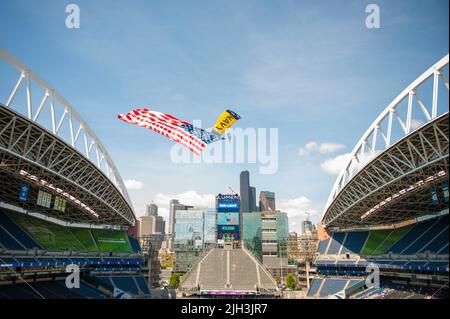 220710-N-IW288-1032 SEATTLE (JUL. 10, 2022) Ein Mitglied des Navy Fallschirmteams, die „Leap Frogs“, legt während einer Zeremonie vor dem Spiel für ein Spiel der National Women's Soccer League zwischen der OL Reign und Portland Thorns mit Fallschirmen ins Lumen-Feld. Die Leap Frogs sind das offizielle Fallschirmdemonstrationsteam der US Navy und Teil des United States Naval Special Warfare Command. Das Fallschirmsprungteam der Leap Frogs Navy besteht aus aktiven Navy-Robben, Special Warfare Combatant-Craft Crewmen (SWCC), Explosive Ordnance Disposal (EOD), Divers und Supportpersonal. (USA Navy Foto von C Stockfoto