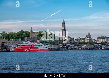 Hamburg, deutschland - 05 15 2022: Blick vom Wasser auf den Hamburger Hafen mit der Helgoland-Fähre Halunder Jet und der Skyline der Stadt Stockfoto