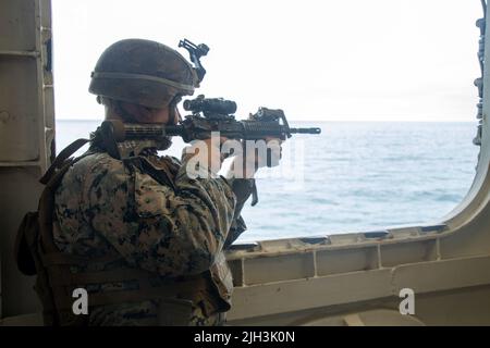 PAZIFIK (13. Juli 2022) – U.S. Marine Corps CPL. Jacob Tetzloff, ein Panzerabwehrkanone, Battalion Landing Team 2/4, 13. Marine Expeditionary Unit, entdeckt während einer Übung zur Verteidigung der Amphibieneinheit an Bord des amphibischen Angriffsschiffs USS Makin Island (LHD 8) im Juli 13 ein simuliertes feindliches Schiff. Die 13. MEU wird derzeit an Bord der USS Makin Island mit Routineoperationen in der US-Flotte von 3. an Bord genommen. (USA Marine Corps Foto von CPL. Carl Matthew Ruppert) Stockfoto