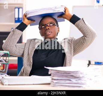 Schwarze weibliche Mitarbeiter mit übermäßiger Arbeit unzufrieden Stockfoto