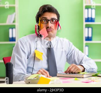 Junge help desk Operator arbeiten im Büro mit vielen widerstreitenden Prioritäten Stockfoto