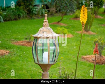 Unbeleuchtete Candelabra im Garten, umgeben von Blumen an einem wolkigen Tag Stockfoto