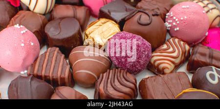 Nahaufnahme einer Auswahl leckerer Schokoladen in Milch, dunklen und aromatisierten Bonbons. Stockfoto