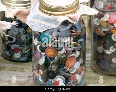 In Gläsern finden sich Hunderte von Knöpfen in allen Formen, Farben und Größen Stockfoto