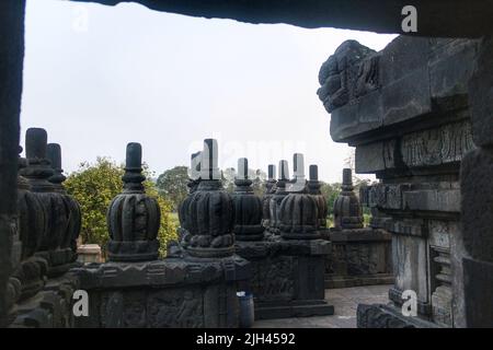 Das Innere eines Tempels im alten Prambanan-Tempelkomplex. Blick auf leeren schmalen Korridor mit Reliefs an der Wand. Keine Personen. Stockfoto