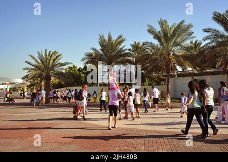 Diverse Color Walk Teilnehmer in Dubai, Vereinigte Arabische Emirate, wandern um den Zabeel Park. Spaß am Wochenende an einem Sommertag. Stockfoto