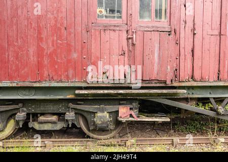 Alte verlassene hölzerne rote Zugkutsche Stockfoto