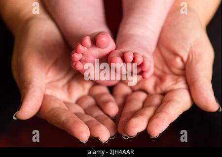 File Photo vom 23/01/16 von einer Mutter, die die Füße eines neuen Babys hält, da sich die Regierung formell bei unverheirateten Frauen entschuldigen sollte, die zwischen den 1950s und 1970s zu unerwünschten Adoptionen „geschleift“ wurden, sagten Parlamentsabgeordnete und Gleichaltrige. Stockfoto