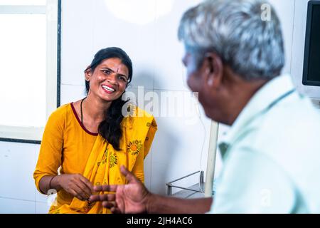 Glücklich lächelnde Tochter mit wiedergeborgenener Vater, der sich auf der Krankenstation unterhielt - Konzept von Beziehung, Kommunikation und Behandlung. Stockfoto