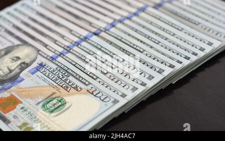 Hundert US-Dollar Hintergrund. Eine Reihe von einhundert Dollar-Scheinen, die für den Wechselkurs, das Geld, das Einkommen oder das Gehalt des US-Dollar stehen. Stockfoto