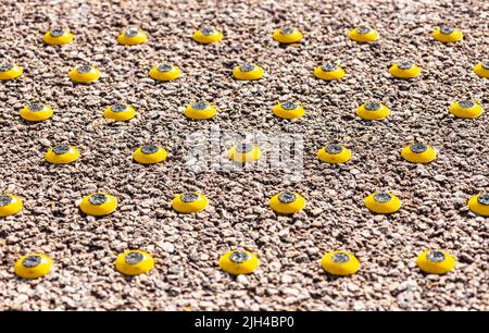 Eine clevere und kleine Möglichkeit, Menschen mit Sehbehinderungen darauf aufmerksam zu machen, dass sie einer Gefahr in der Nähe sind, in diesem Fall dem Bahnsteig. Stockfoto