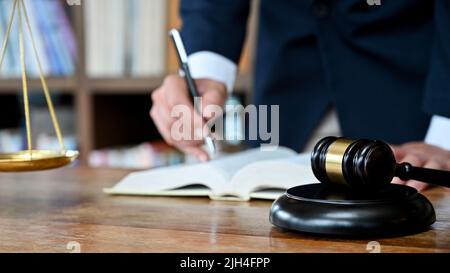 Professioneller männlicher Anwalt oder Rechtsanwalt, der an seinem Schreibtisch im Gerichtssaal oder im Bürozimmer arbeitet. Richter und Rechtskonzept. Zugeschnittenes Bild Stockfoto