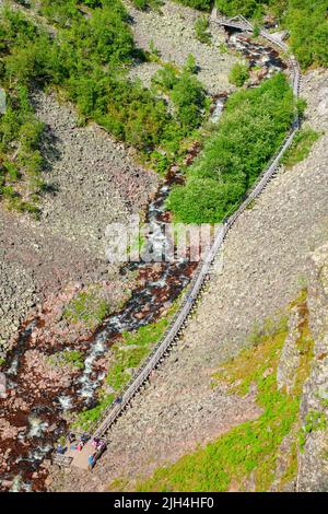 Wanderer auf einem Wanderweg entlang eines Flusses in einer Fulufjällets Schlucht in Schweden Stockfoto