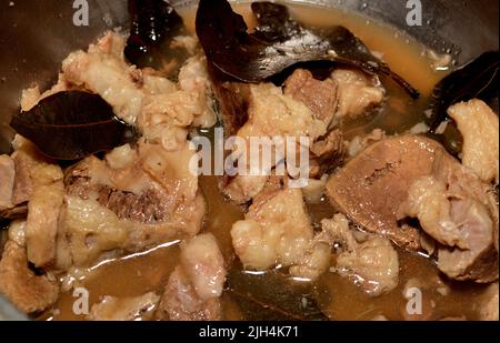 Stücke von gehacktem Fleisch Beefsteak auf heißem Dampf mit Zwiebelscheiben, Salz und schwarzem Pfeffer, Lorbeer und Kardamom gekocht, selektive Fokus Rindfleisch Stücke werden Stockfoto