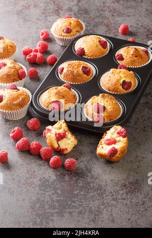 Frische hausgemachte leckere Himbeer-Muffins aus der Nähe auf dem Tisch. Vertikal Stockfoto