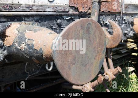 Rostiger, unrestaurierter Puffer auf einem alten hölzernen Zugwagen Stockfoto
