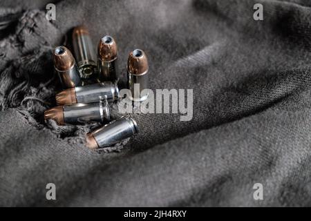 9mm verbergen halbautomatische Pistole mit Jacke heiligen Punkt Kugel auf Stoff Hintergrund Stockfoto