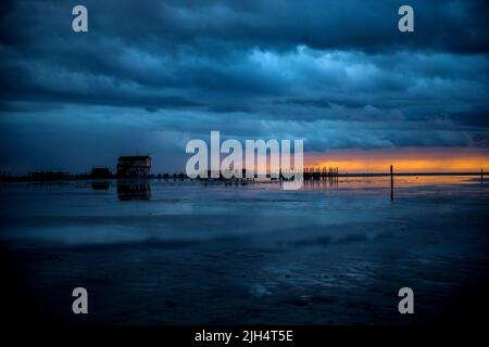 Pfahlbauten am Strand bei Sonnenuntergang, Deutschland, Schleswig-Holstein, Sankt Peter-Ording Stockfoto