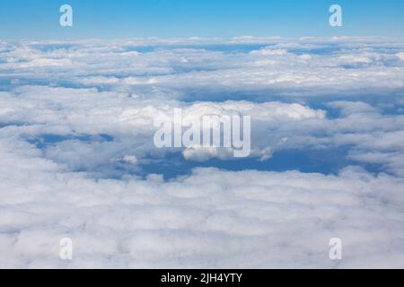Wolkenpanorama aus dem Flugzeugfenster. Fliegen in der Stratosphäre . Wetterprognose-Konzept Stockfoto