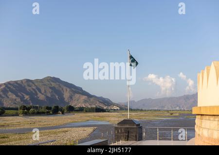 Die Nationalflagge Pakistans winkt mit einer wunderschönen Landschaft im Hintergrund Stockfoto