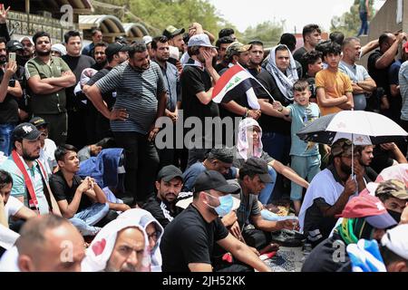 Bagdad, Irak. 15.. Juli 2022. Anhänger des irakischen schiitischen Geistlichen Muqtada al-Sadr, Anführer der Sadrist-Bewegung, versammeln sich auf den Straßen, um das wöchentliche muslimische Freitagsgebet auf den Ruf ihres Führers zu verrichten. Quelle: Ameer Al-Mohammedawi/dpa/Alamy Live News Stockfoto