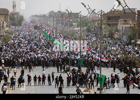 Bagdad, Irak. 15.. Juli 2022. Tausende Anhänger des irakischen schiitischen Geistlichen Muqtada al-Sadr, Anführer der Sadrist-Bewegung, versammeln sich auf den Straßen, um das wöchentliche muslimische Freitagsgebet auf den Ruf ihres Führers zu verrichten. Quelle: Ameer Al-Mohammedawi/dpa/Alamy Live News Stockfoto