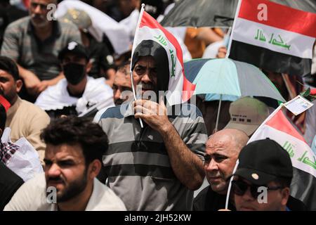 Bagdad, Irak. 15.. Juli 2022. Anhänger des irakischen schiitischen Geistlichen Muqtada al-Sadr, Anführer der Sadrist-Bewegung, versammeln sich auf den Straßen, um das wöchentliche muslimische Freitagsgebet auf den Ruf ihres Führers zu verrichten. Quelle: Ameer Al-Mohammedawi/dpa/Alamy Live News Stockfoto