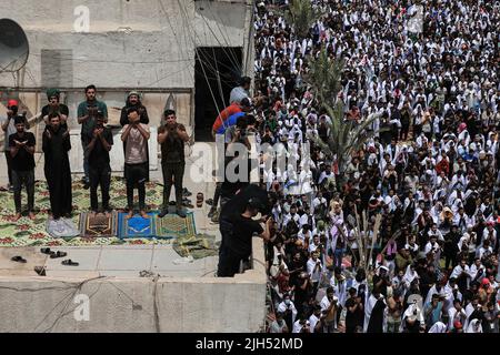 Bagdad, Irak. 15.. Juli 2022. Tausende Anhänger des irakischen schiitischen Geistlichen Muqtada al-Sadr, Anführer der Sadrist-Bewegung, versammeln sich auf den Straßen, um das wöchentliche muslimische Freitagsgebet auf den Ruf ihres Führers zu verrichten. Quelle: Ameer Al-Mohammedawi/dpa/Alamy Live News Stockfoto