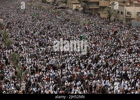 Bagdad, Irak. 15.. Juli 2022. Tausende Anhänger des irakischen schiitischen Geistlichen Muqtada al-Sadr, Anführer der Sadrist-Bewegung, versammeln sich auf den Straßen, um das wöchentliche muslimische Freitagsgebet auf den Ruf ihres Führers zu verrichten. Quelle: Ameer Al-Mohammedawi/dpa/Alamy Live News Stockfoto