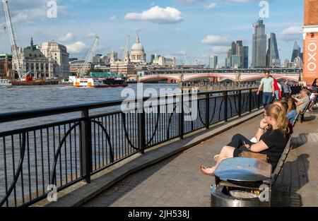 London, England, Großbritannien - 21 2019. Juli: Am Londoner Südufer genießen die Menschen das warme, sonnige Wetter, beobachten die Boote, die sich auf und ab der Themse bewegen und bewundern die Stockfoto