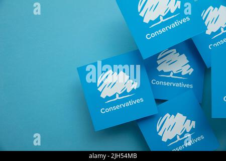 LONDON, Großbritannien - Juli 2022: Konservatives Logo der britischen politischen Partei vor blauem Hintergrund Stockfoto