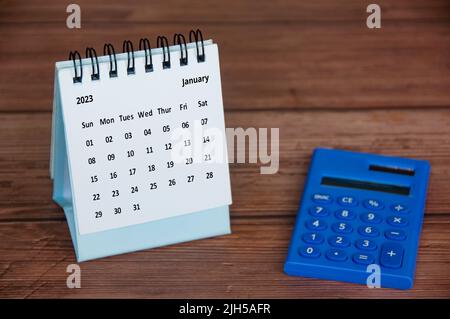 Januar 2023 weißer Tischkalender mit Rechner auf Holztisch anpassbar für Ideen von Text. Konzept und Platz zum Kopieren im neuen Jahr Stockfoto