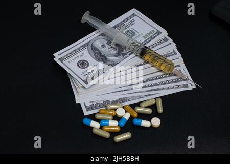 Medikamentenspritze und Geldnote auf schwarzem Hintergrund Stockfoto