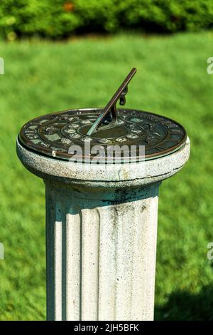 Antike Sonnenuhr auf einem Sockel an sonnigen Tagen im Garten, New Jersey Botanical Garden Stockfoto