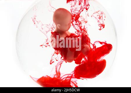 Abtreibungskonzept. Babypuppe im roten Blut sieht aus wie eine Abtreibung. Stockfoto