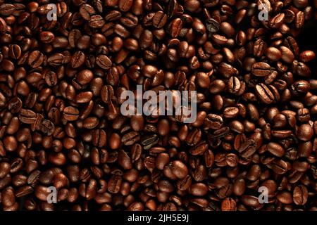 Draufsicht auf geröstete Kaffeebohnen für Hintergrund und Textur. Als Hintergrund und Textur können geröstete Kaffeebohnen gestapelt werden. Stockfoto