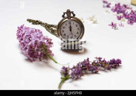 Unschärfe-Effekte für alte Uhren. Konzept des Vergehens, die Uhr zerfällt in Stücke. Analoge Uhr mit Dispergiereffekt. Konzept Leben und Tod. Fliederfluss Stockfoto