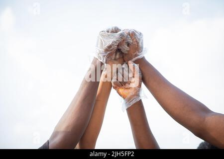 Vier Fäuste afrikanischer Menschen werden in den Himmel erhoben und protestieren gemeinsam Stockfoto