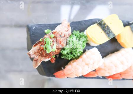 Sushi oder Gyuuniku Sushi, Reis mit rohem Rindfleisch oder Rindfleisch Sushi gekrönt Stockfoto